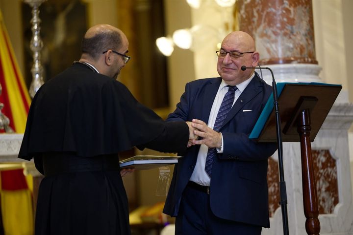 The Grand Chancellor, H.E. Massimo J. Ellul, receives a book at the Basilica of Christ the King.
